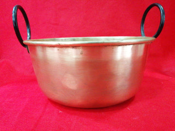 Caldero de metal con asas de hierro en fondo rojo, ideal para decoración vintage en hogar o jardín. Excelente calidad y estado de conservación.