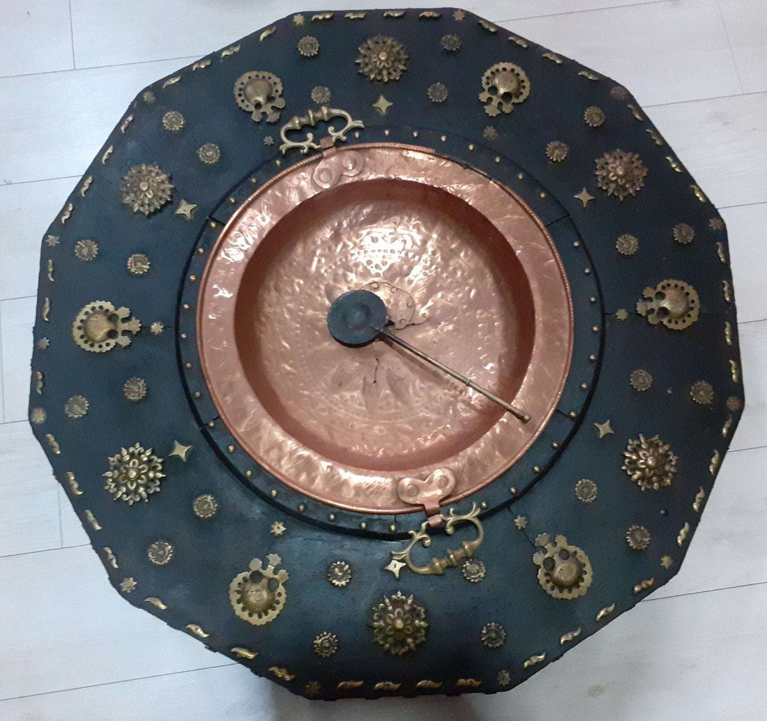 Brasero de cobre vintage con asas metálicas y mesa decorativa del siglo XVIII, ideal para decoración de interiores clásicos.