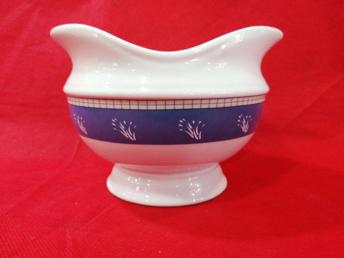 Salsera de porcelana de alta calidad con diseño elegante en blanco y azul, ideal para decoración clásica en el hogar o colecciones refinadas.