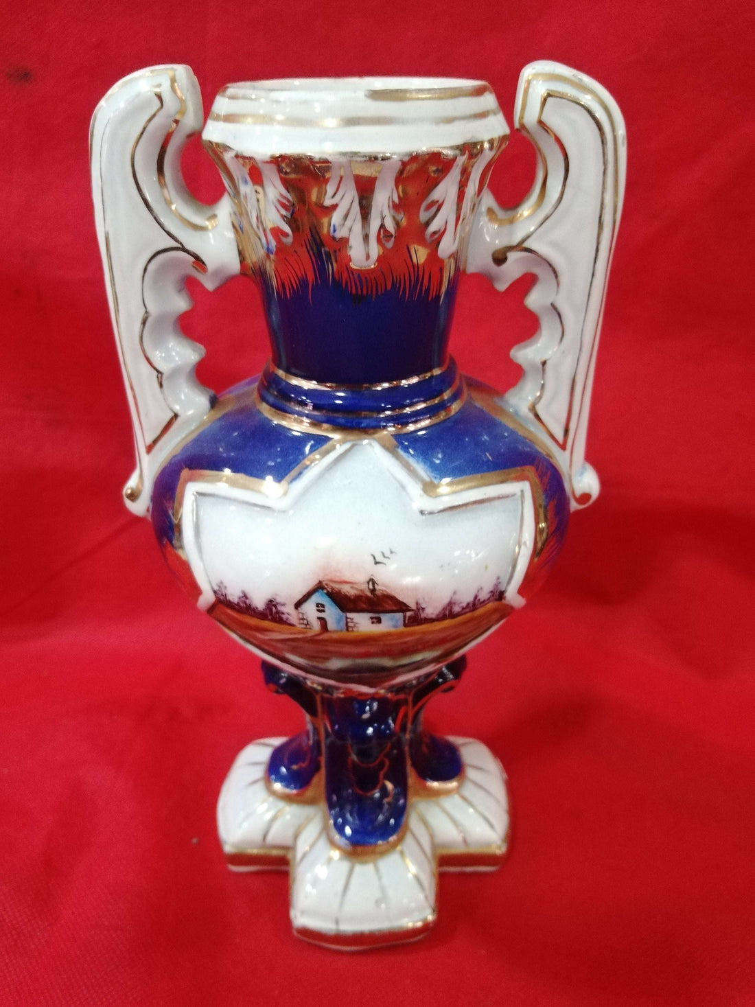 Jarrón de cerámica pintado a mano, diseño exclusivo con flores y detalles dorados sobre fondo azul y blanco. Ideal para decoración elegante y antigua.