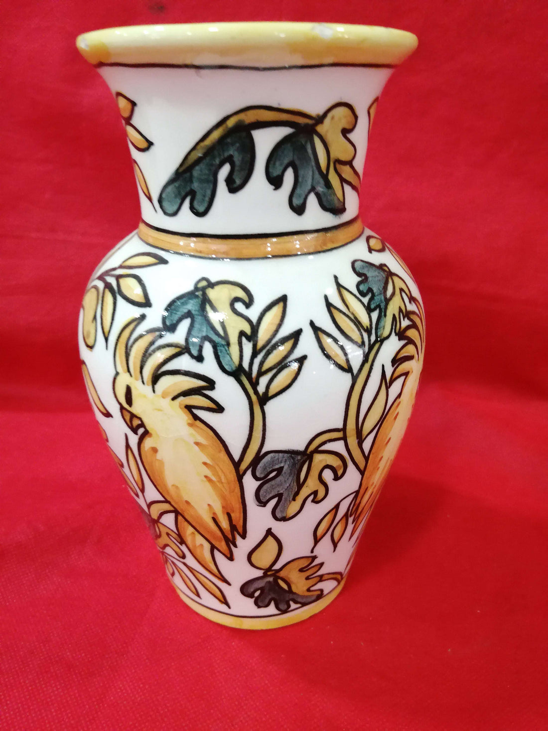 Jarrón de cerámica pintado a mano con diseño floral en tonos ocres y verdes, estilo artesanal y único para decoración de interiores.