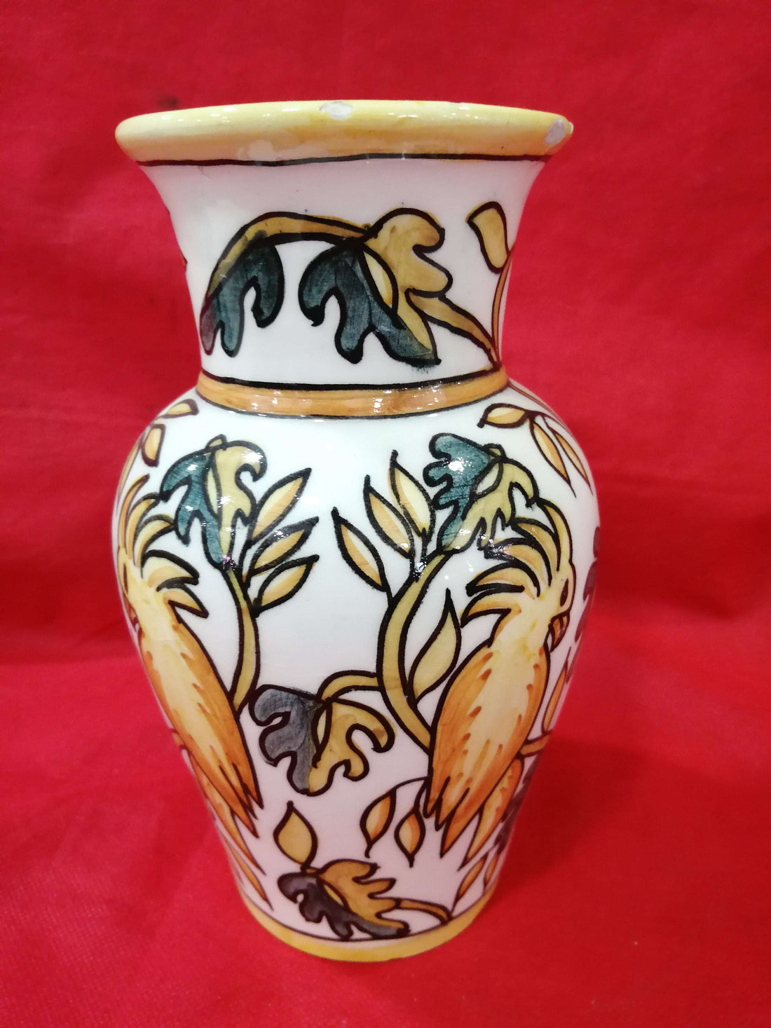 Jarrón de cerámica pintado a mano con diseño floral en tonos ocres y verdes, estilo artesanal y único para decoración de interiores.