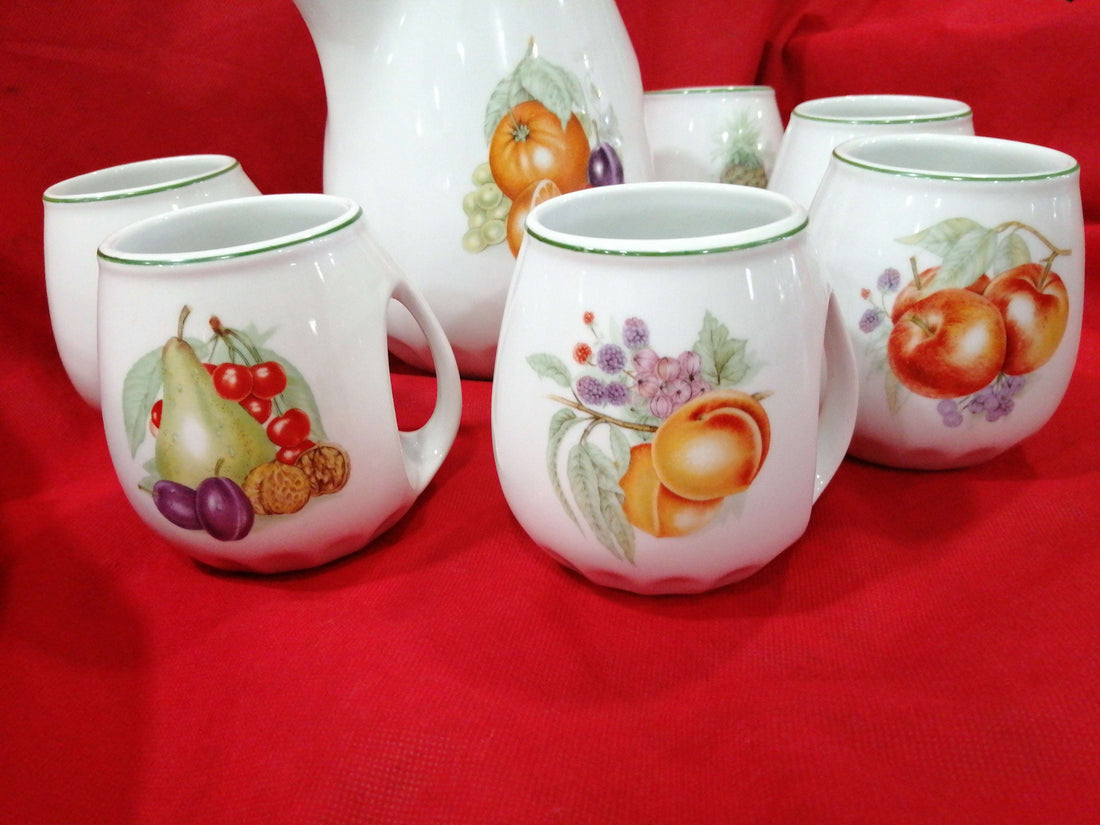 Juego de jarra y jarritas de porcelana Sanbo de alta calidad con diseño de frutas sobre fondo blanco, ideal para decoración clásica del hogar.