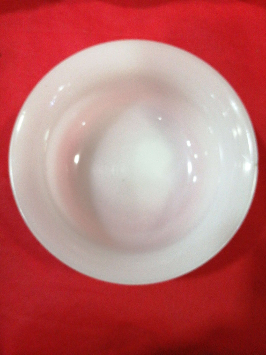 Cuenco de opalina blanca con acabado brillante sobre fondo rojo, ideal para decoración vintage en el hogar. Elegancia y calidad en un solo producto.