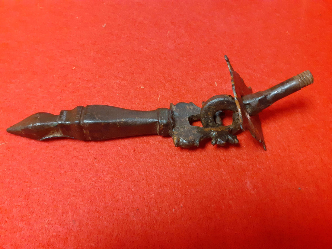 Aldaba Llamador de Puerta S. XVIII de hierro forjado sobre fondo rojo, diseño clásico con detalles ornamentales. Ideal para decoración de puertas rústicas.