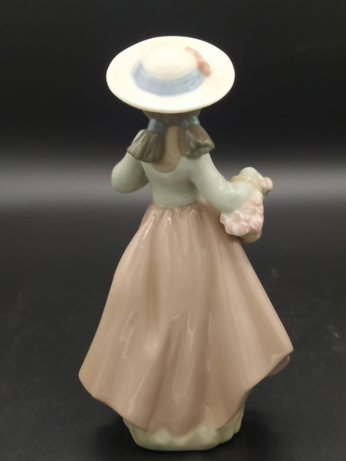 Figura de porcelana Nao Lladó de niña con sombrero y cesta de flores, ideal para decoración de interiores y coleccionistas de arte.