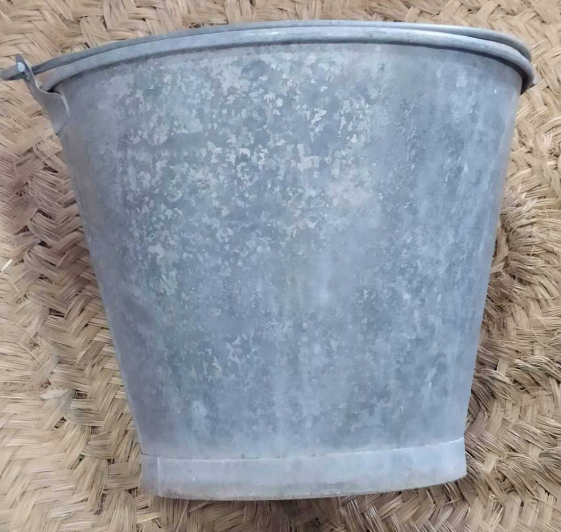 Cubo de zinc antiguo de calidad superior con acabado envejecido, ideal para decoración rústica en interiores o jardines. Estilo industrial auténtico.