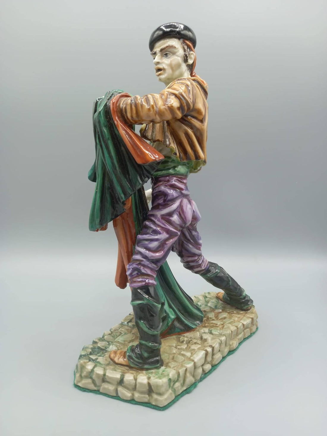 Figura de porcelana Torero Algora en pose dinámica, con traje goyesco y capa multicolor. Artesanía española ideal para decoración elegante.