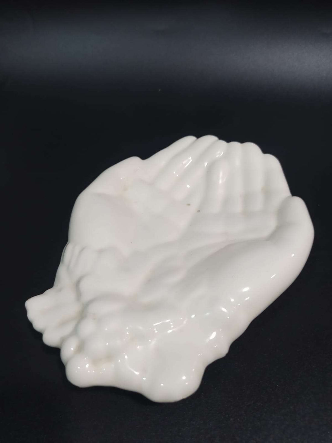 Jabonera en cerámica con diseño de manos blancas, ideal para decoración de baño o cocina. Calidad única y estilo artesanal elegante.