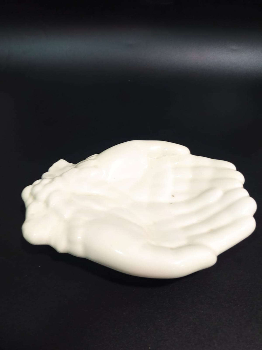 Jabonera en cerámica con diseño de manos blancas, ideal para decoración de baño o cocina. Calidad única y estilo artesanal elegante.