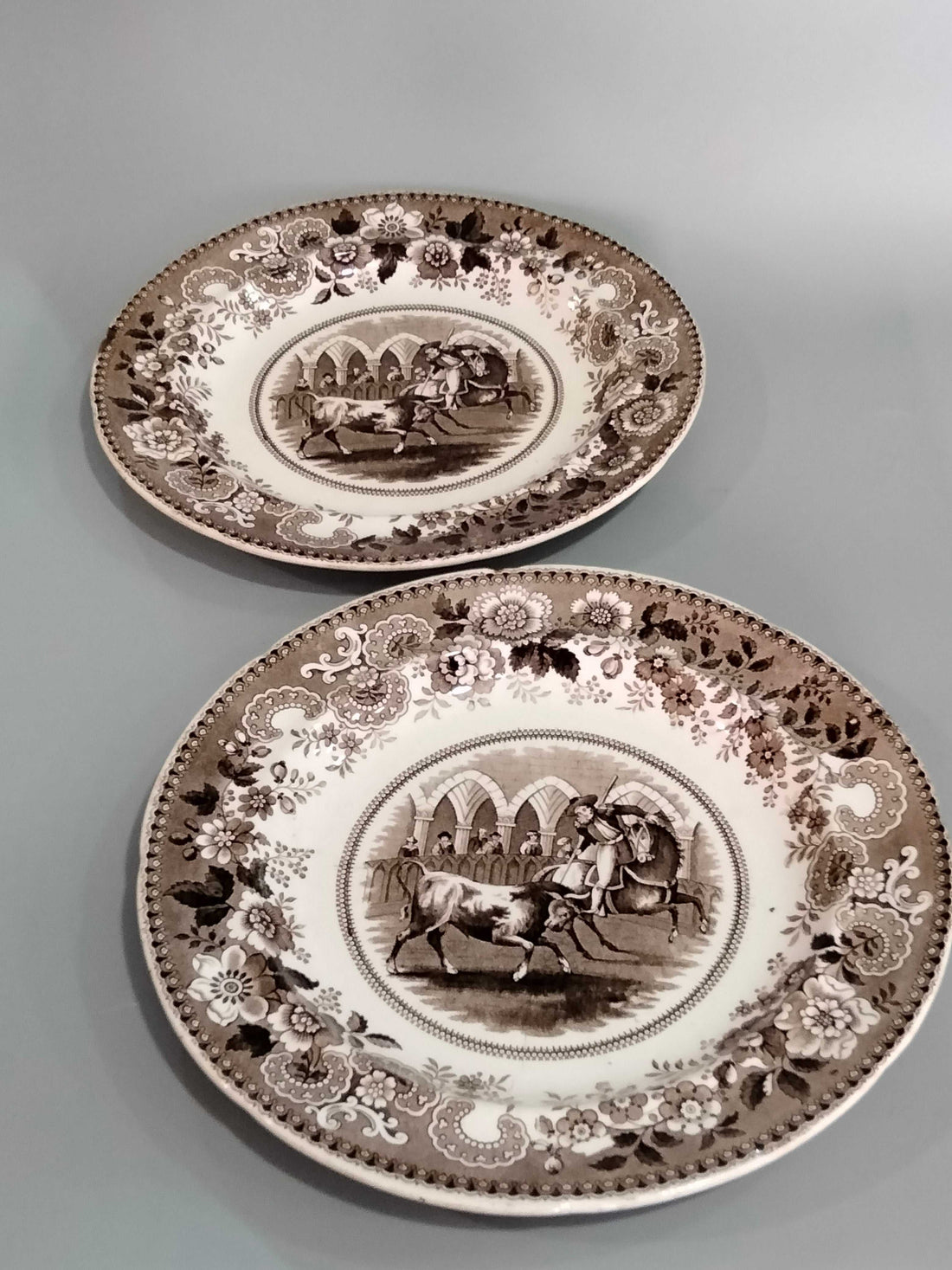 Platos de porcelana francesa antigua con escena de rejoneo en tonos sepia, ideales para decoración vintage en el hogar. Calidad premium y diseño clásico.