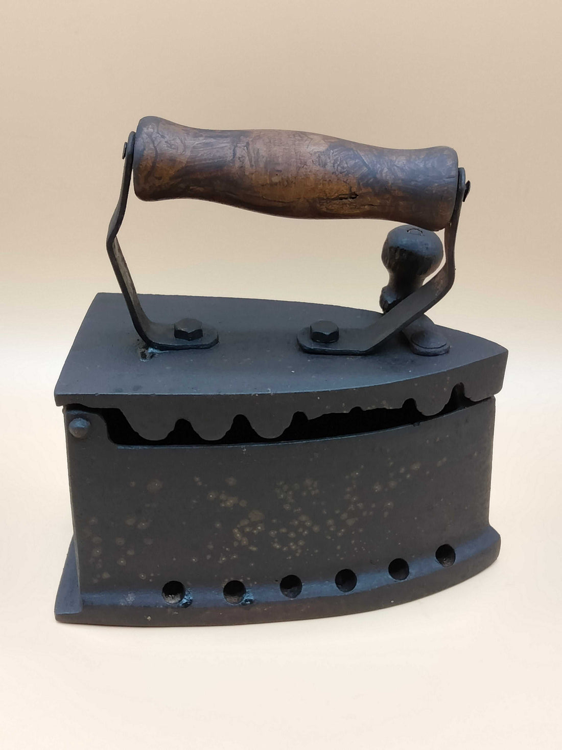 Plancha de carbón fundición antigua con tapa abierta y mango de madera, ideal para decoración vintage en hogar o colección de antigüedades.