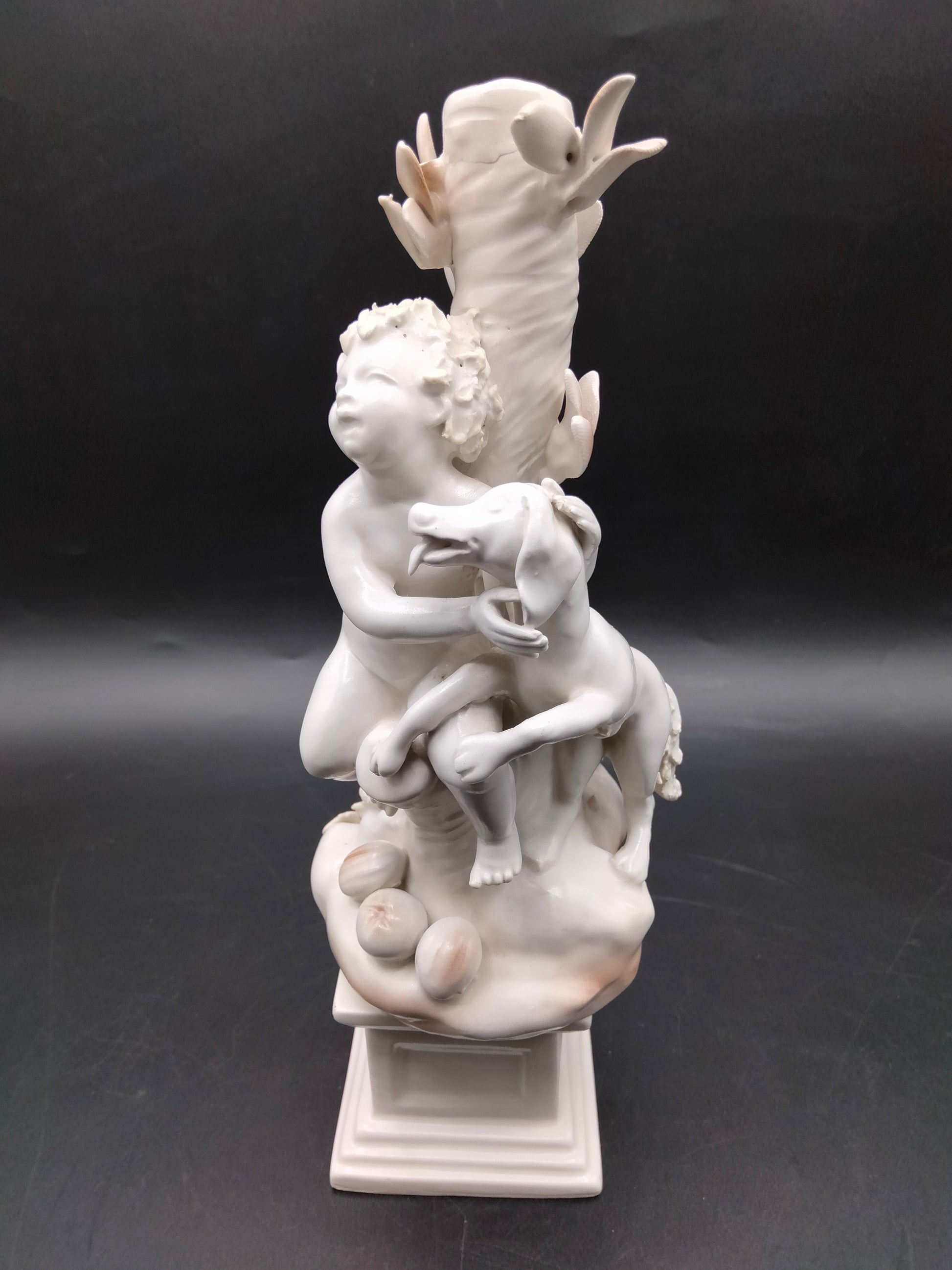 Figura Niños Jugando con Perro - Figura | Porcelana Alemana mostrando niño abrazando perro junto a árbol, pieza ornamental para hogar o jardín.