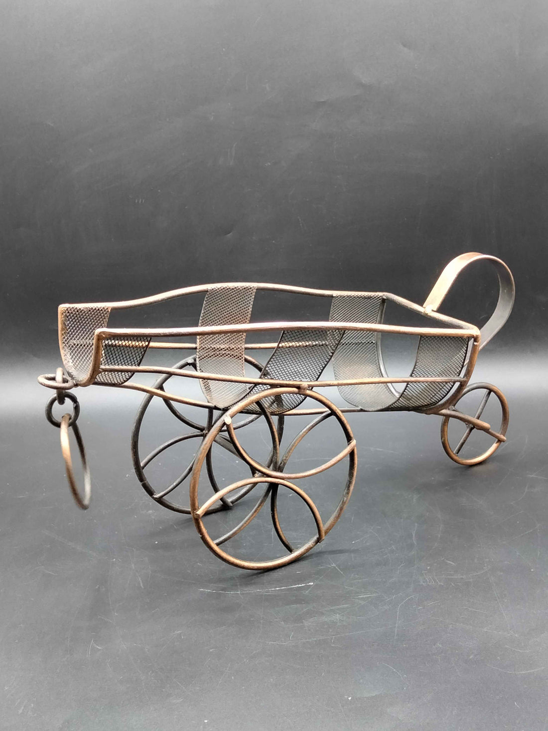 Portabotellas de cobre en forma de carro con diseño vintage y elegante, ideal para decoración de mesas en estilo antiguo o árabe.