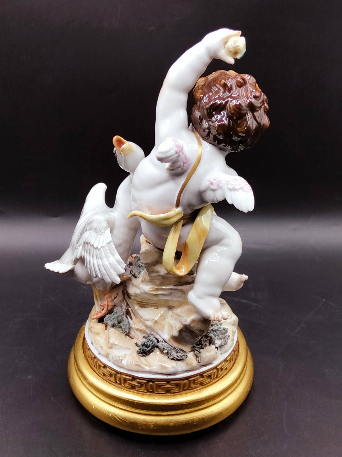 Figura Ángel con Pato - Elegancia y Lujo | Decoración en porcelana fina, muestra un ángel alado interactuando con un pato sobre base dorada.