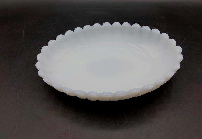 Bandeja ovalada de opalina blanca con borde dentado, pieza única ideal para decoración vintage o centro de mesa elegante.