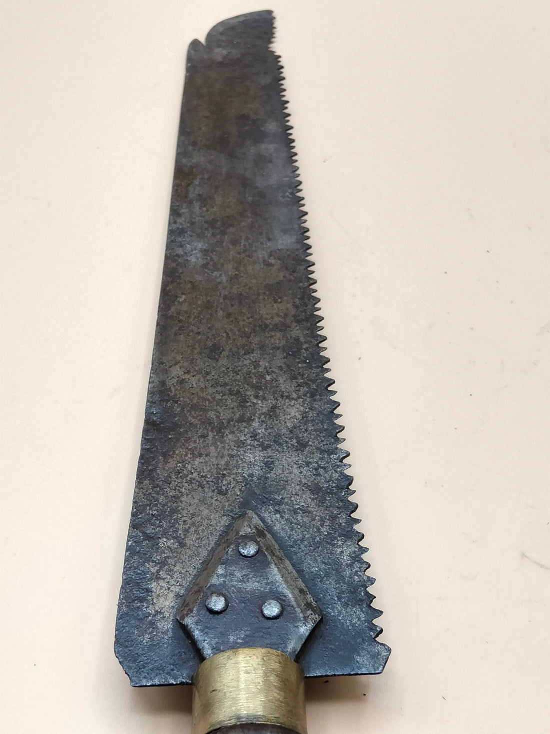 Sierra de mano antigua para carpintería con mango de madera oscura y hoja metálica dentada, ideal para decoración vintage en hogar y jardín.