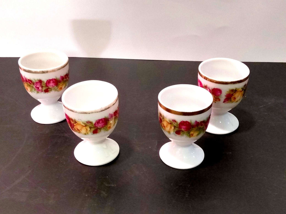 Juego de 4 hueveros de porcelana decorados con motivos frutales en tonos rojos y amarillos, ideal para decoración vintage de cocina.