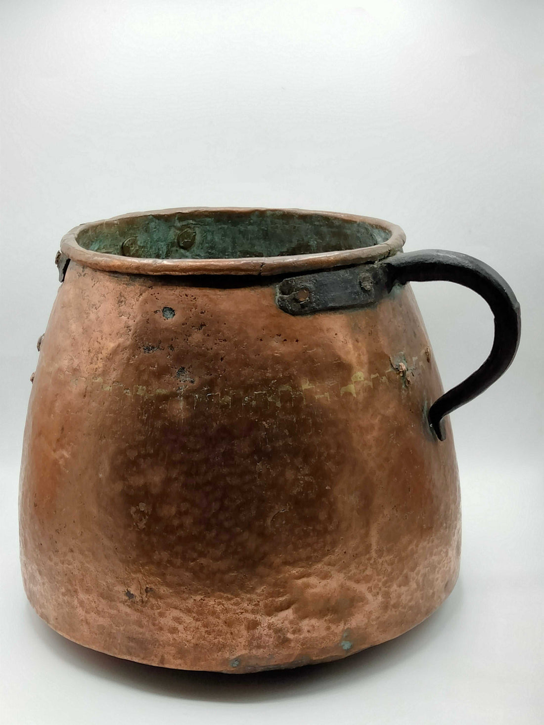 Olla de cobre del siglo XIX con acabado martillado y asa de hierro, ideal para decoración vintage en interiores rústicos o colecciones antiguas.