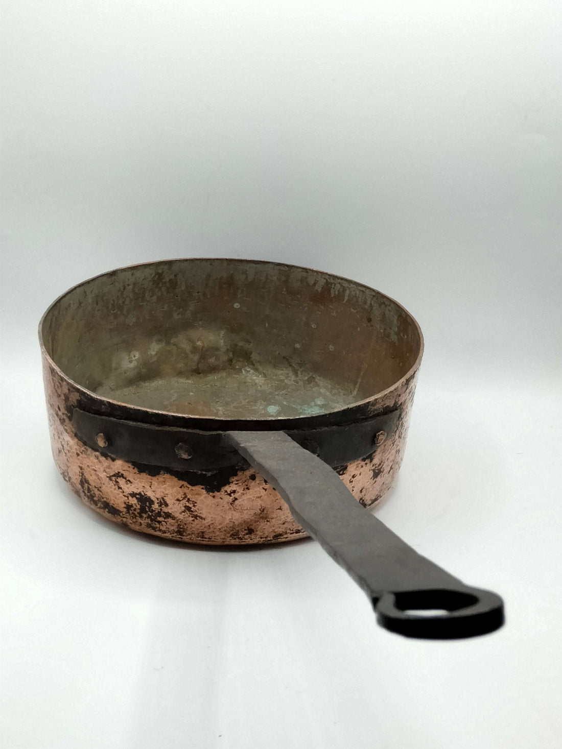 Cazo de cocina francesa de cobre con mango largo de hierro remachado, ideal para decoración rústica en cocinas de estilo vintage.