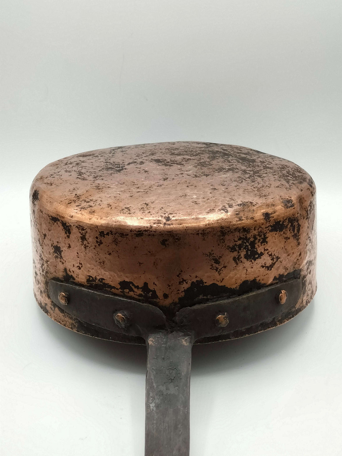 Cazo de cocina francesa de cobre con mango largo de hierro remachado, ideal para decoración rústica en cocinas de estilo vintage.