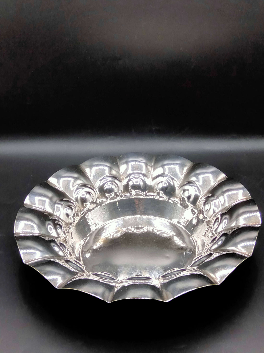 Plato de metal plateado con diseño ondulado, ideal para decoración elegante en el hogar. Parte de la colección Plato de Metal Plateado - Elegancia y Calidad.