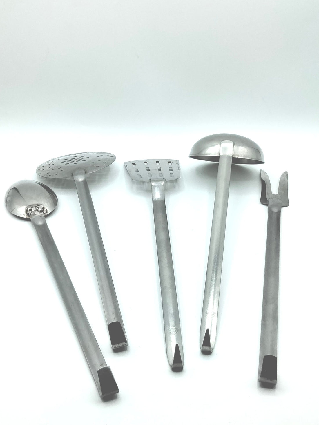 Juego completo de 5 utensilios de cocina antiguos en acero inoxidable, presentados sobre una superficie de madera.