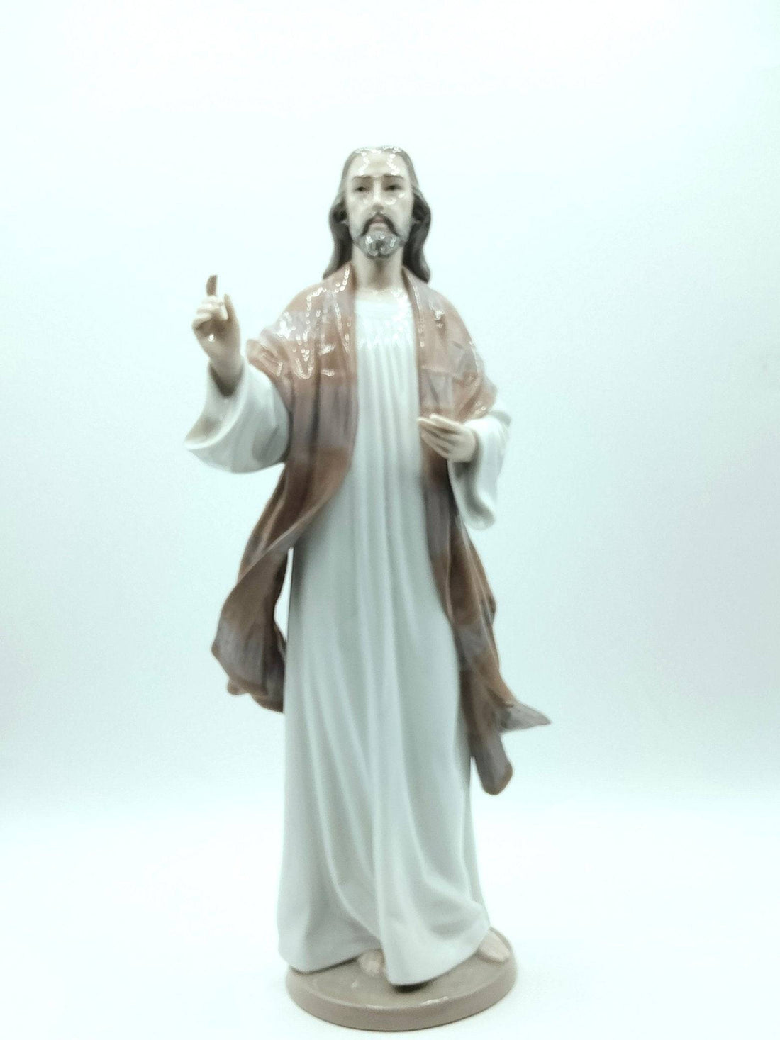 Figura de porcelana Jesús de Lladró 1996 en vista frontal, con túnica blanca y manto marrón, ideal para decoración religiosa de alta calidad.