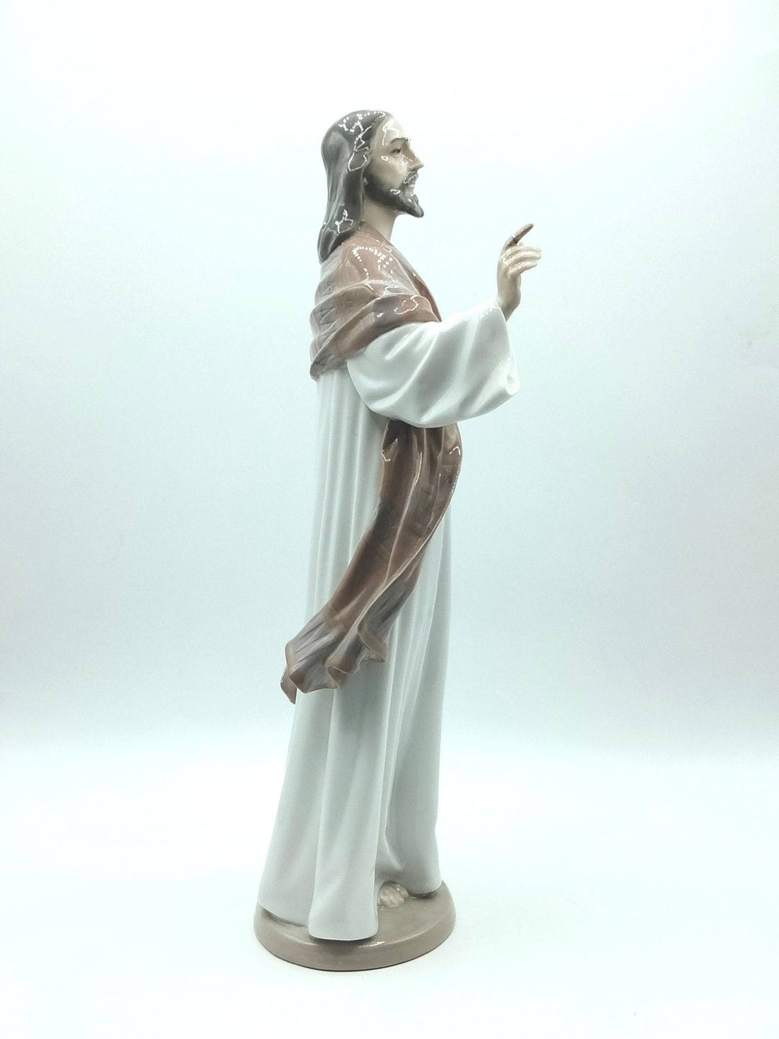 Figura de porcelana Jesús de Lladró 1996 en vista frontal, con túnica blanca y manto marrón, ideal para decoración religiosa de alta calidad.