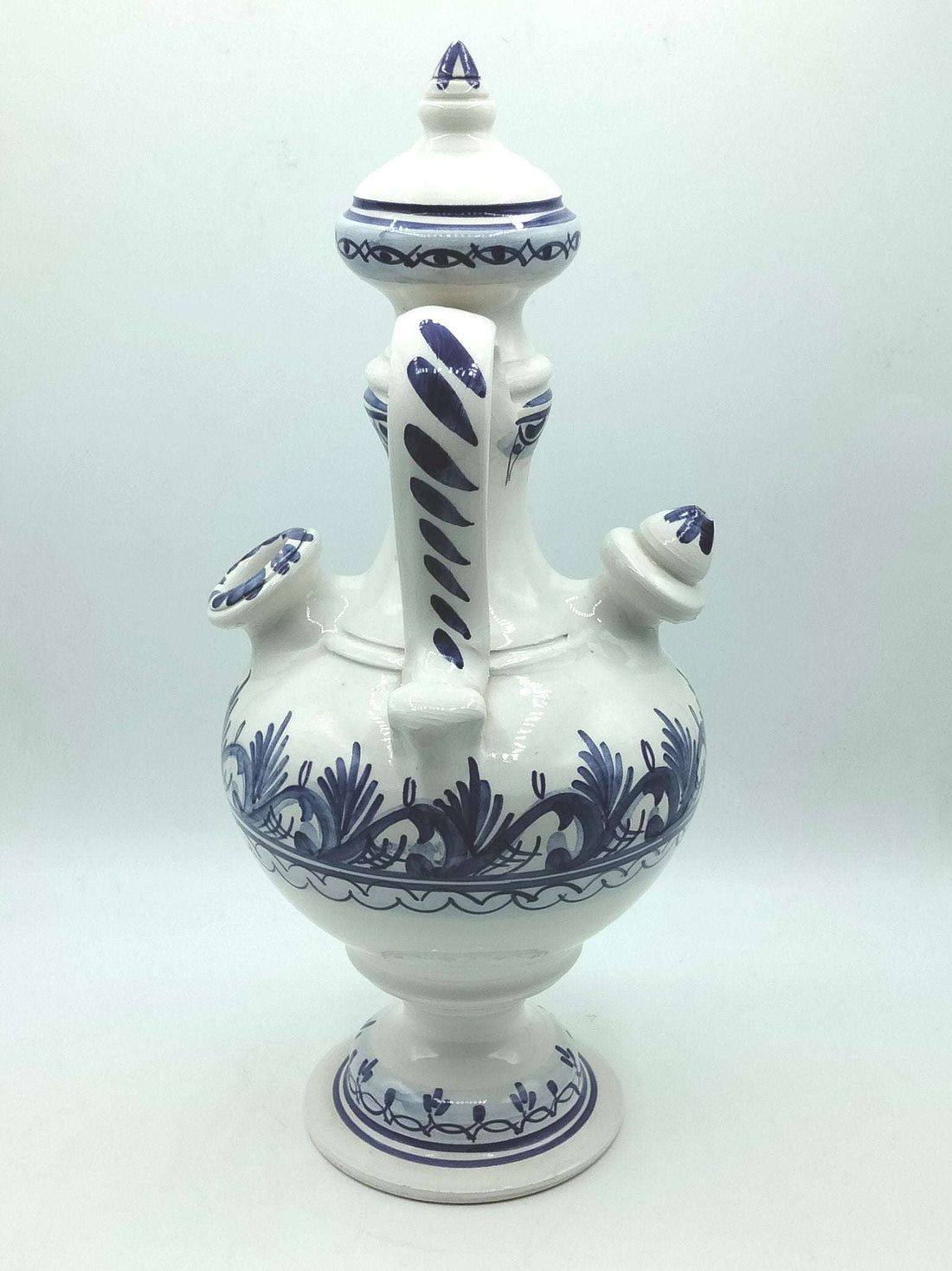 Botijo artesanal azul de cerámica esmaltada con detalles pintados a mano en blanco y azul. Decoración única para el hogar con estilo tradicional.