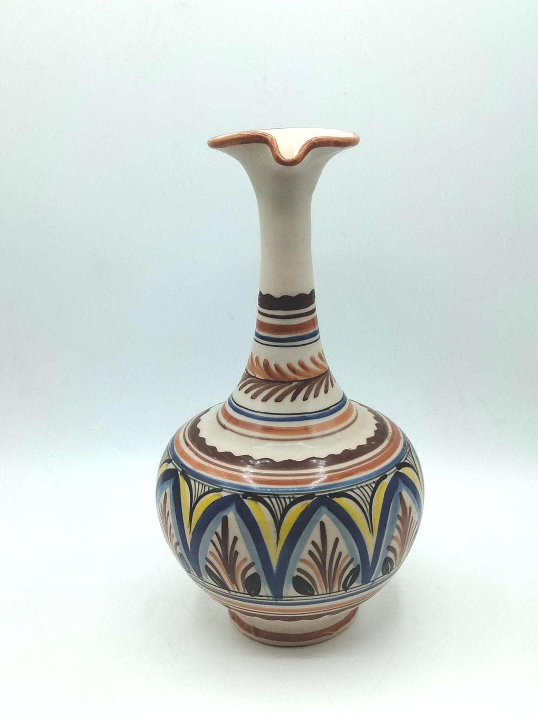 Jarra ceramica artesanal con diseño elegante pintado a mano en tonos tierra, azul y amarillo. Ideal para decoración de interiores estilo rústico.