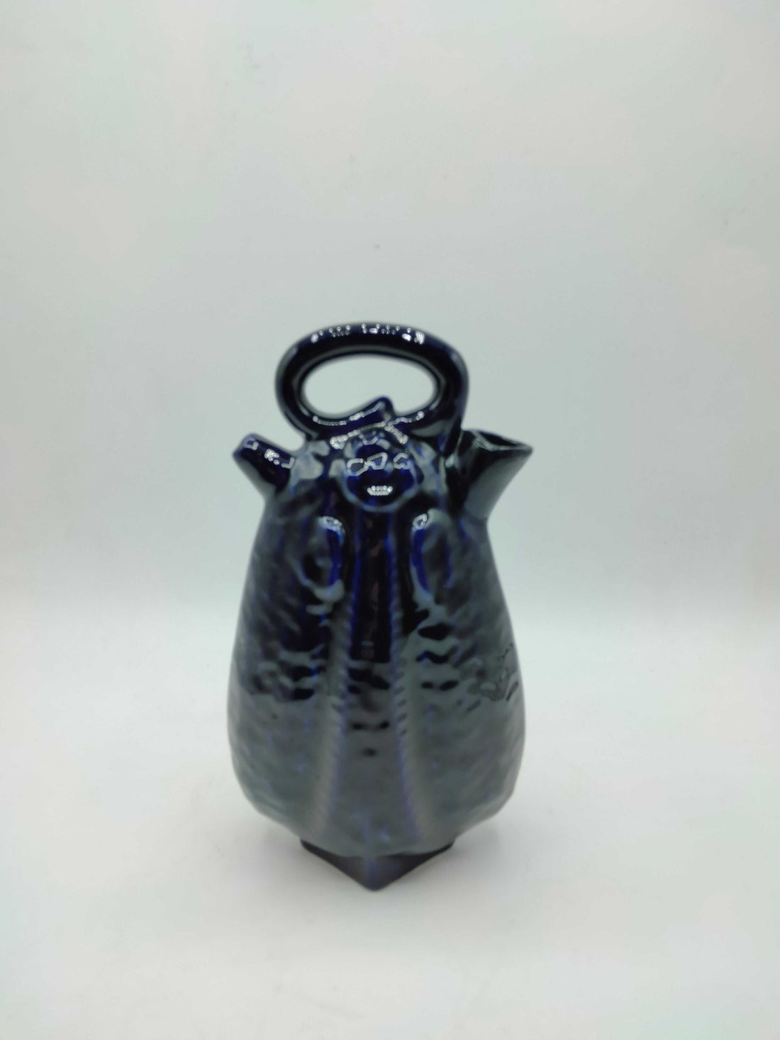 Otijo artesanal de cerámica azul con acabado brillante y diseño elegante, ideal para decoración de interiores. Calidad excepcional y estilo único.