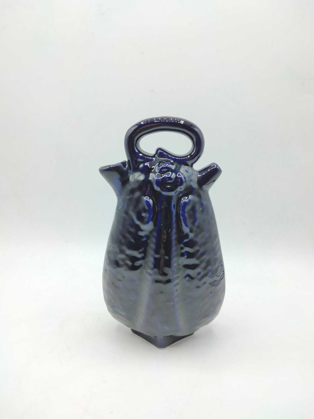 Otijo artesanal de cerámica azul con acabado brillante y diseño elegante, ideal para decoración de interiores. Calidad excepcional y estilo único.