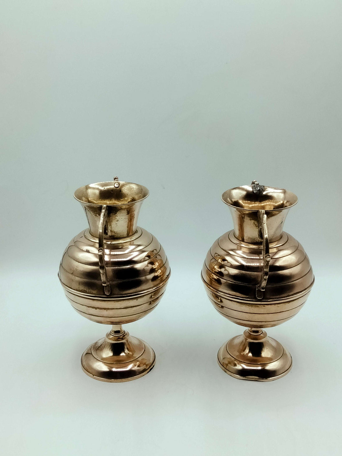 Ánforas de bronce con detalles elegantes y asas ornamentadas, ideales para decoración clásica en el hogar. Producto exclusivo de Cositas Antiguas.
