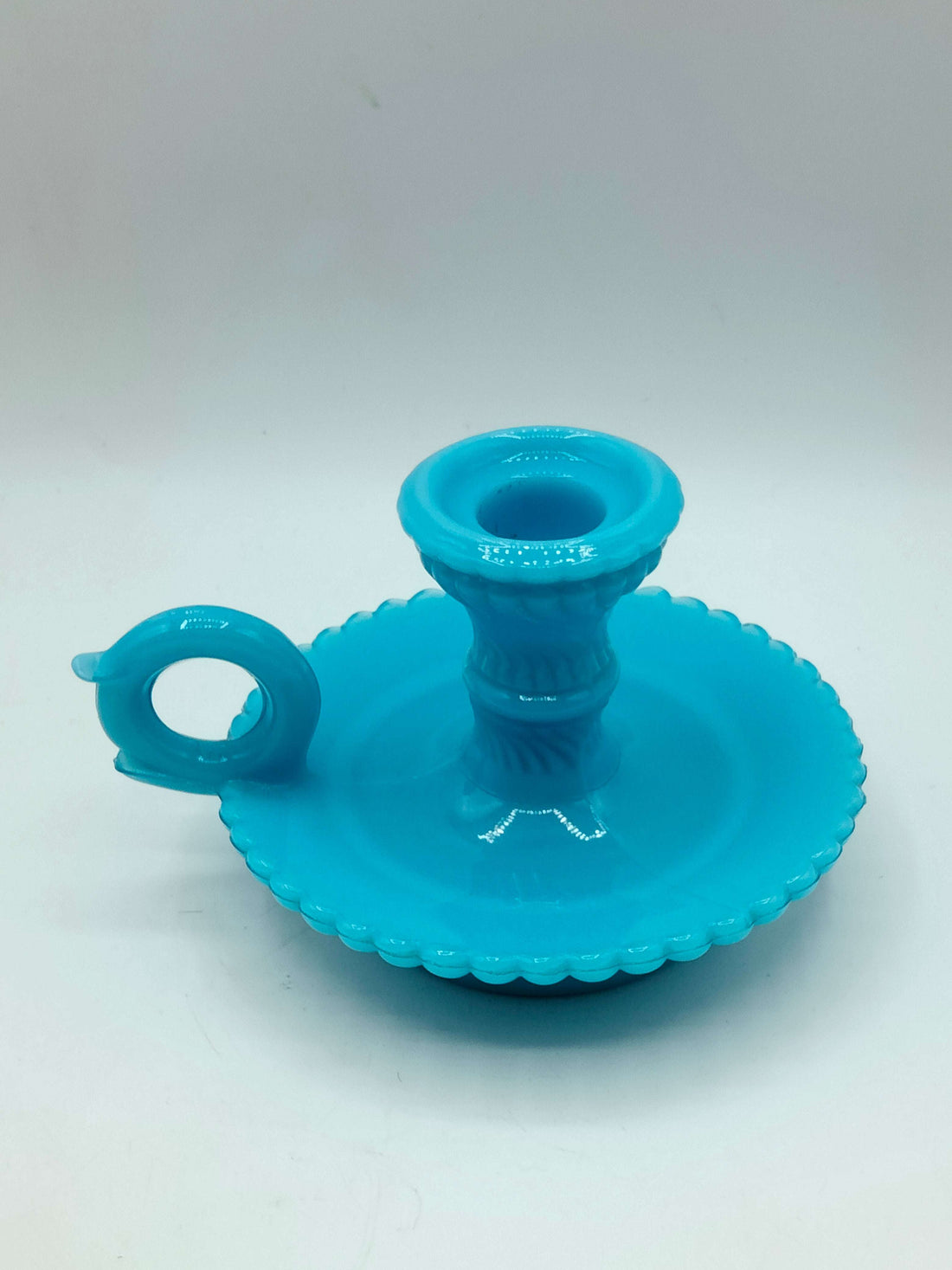 Palmatoria de opalina azul elegante con borde ondulado y mango circular, vista frontal