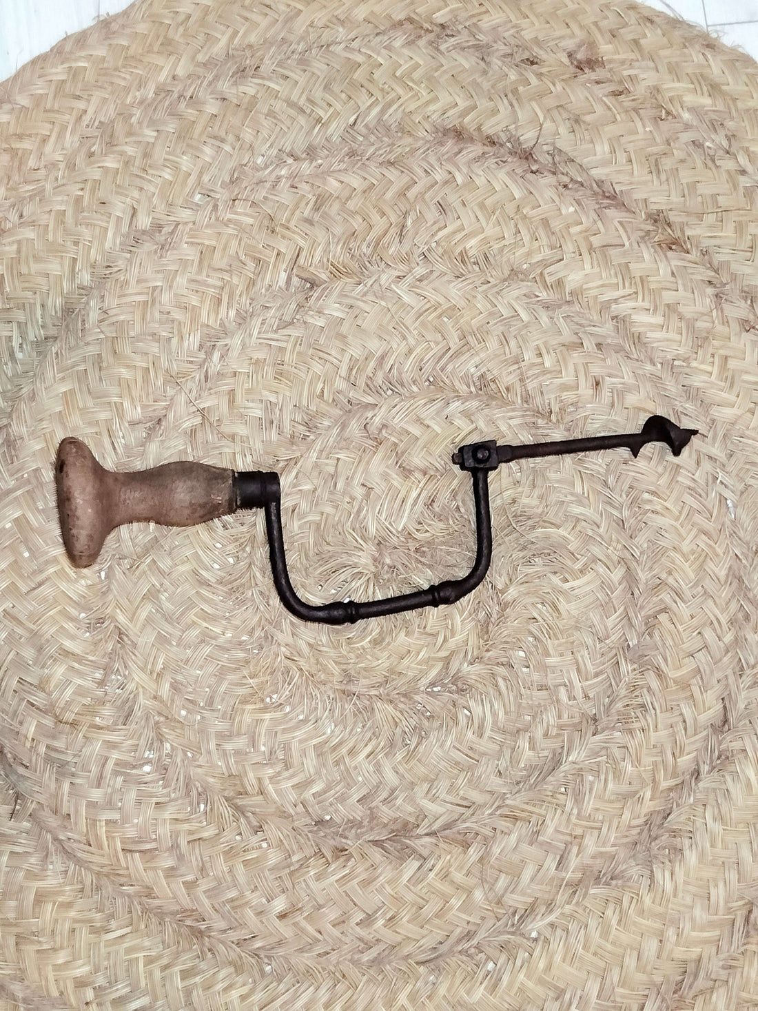 Taladro manual con mango de madera y broca cuadrada desmontada, ideal para decoración vintage en hogar y jardín. Diseño clásico para coleccionistas.