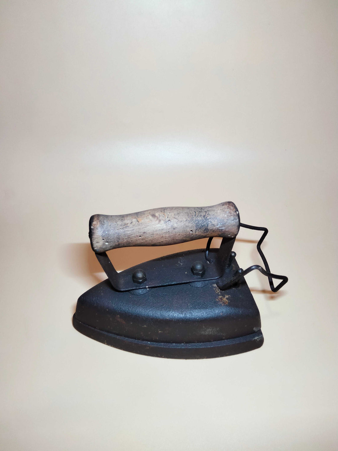 Plancha eléctrica antiguo con apoyador, mango de madera y cuerpo de hierro, ideal para decoración vintage en hogar o colección retro.