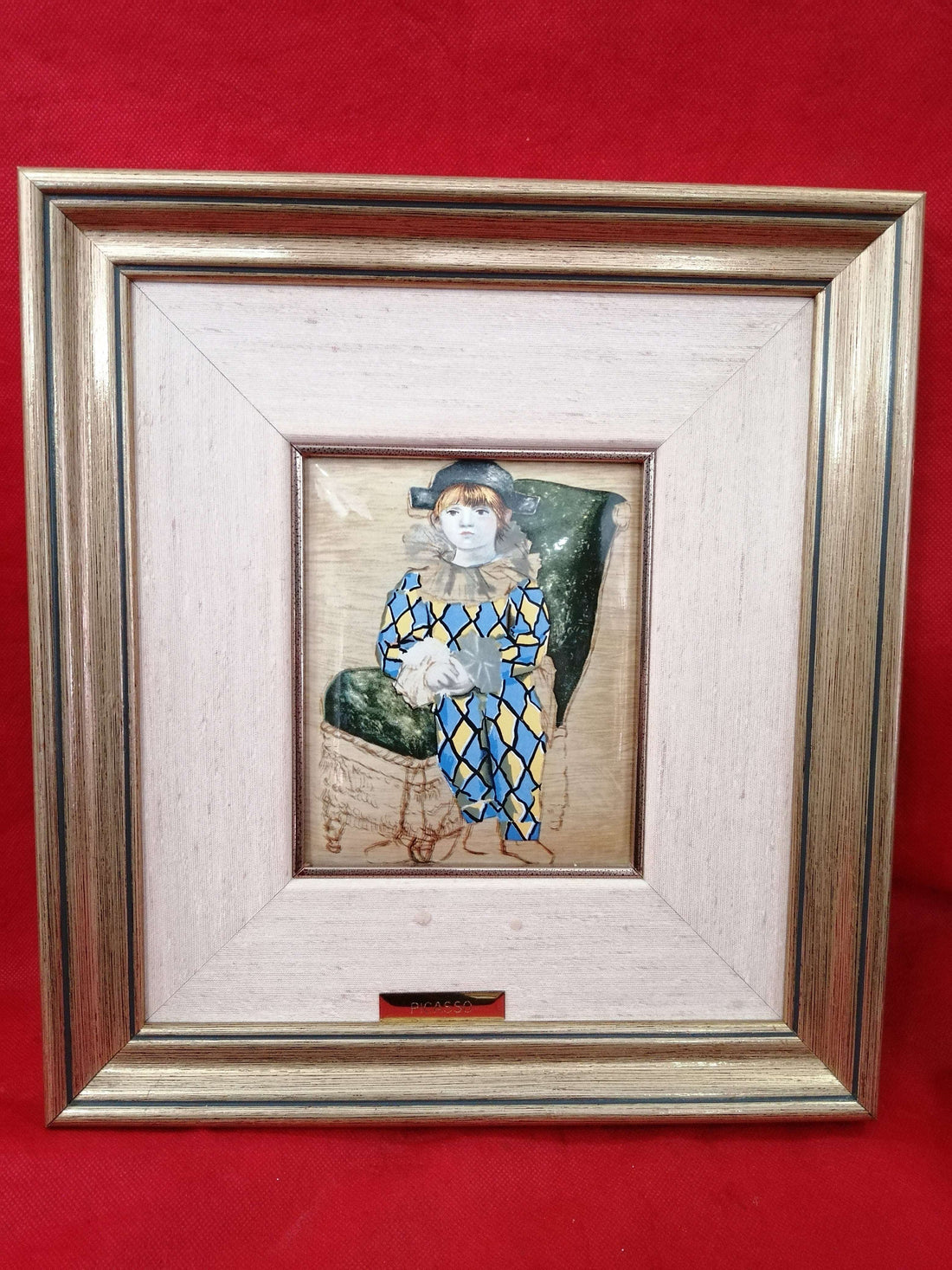 Esmalte Picasso motivo arlequín: arte exclusivo y original con figura infantil en traje de rombos azules y amarillos sobre silla verde. Decoración artística ideal para coleccionistas de arte contemporáneo.