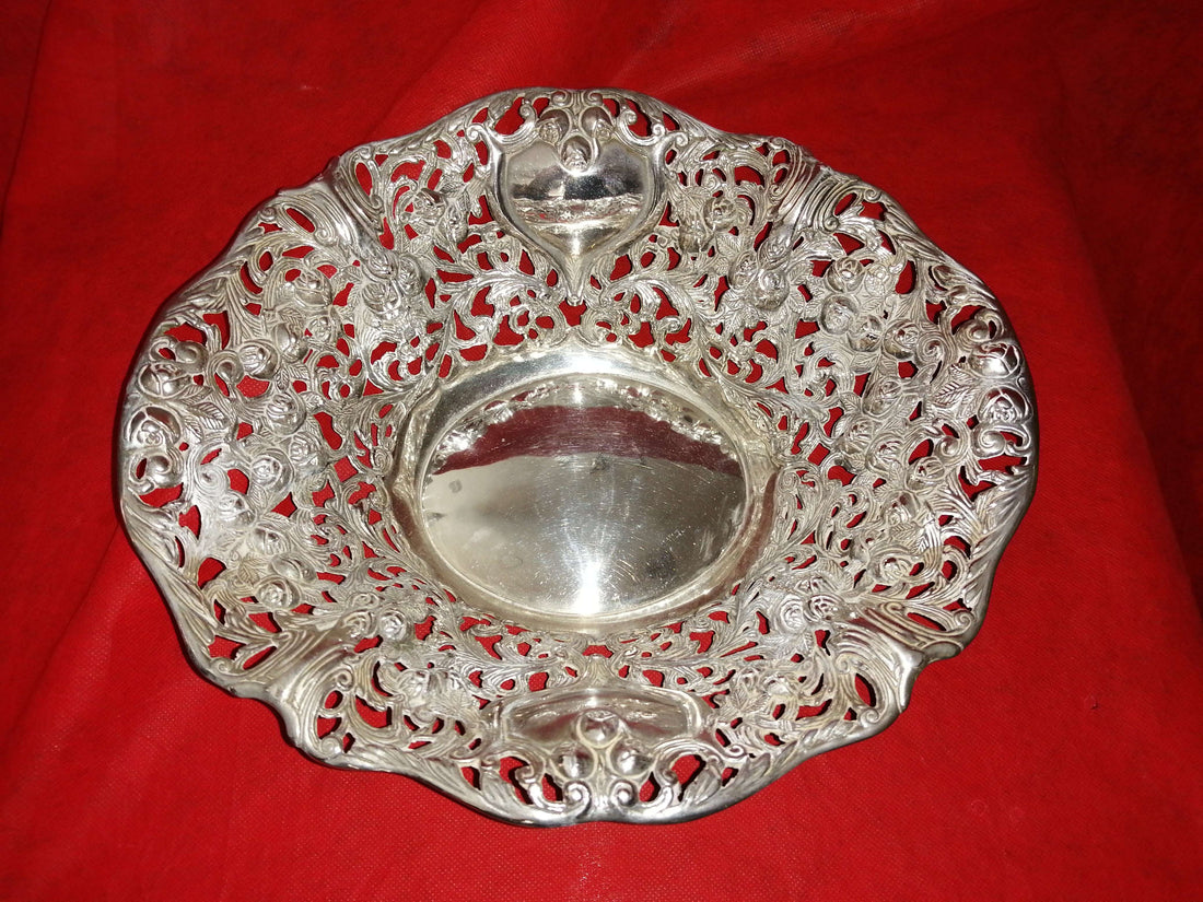 Panera Labrada de Metal Plateado con diseño calado ornamental, ideal para decoración de mesa elegante en estilo antiguo y sofisticado.