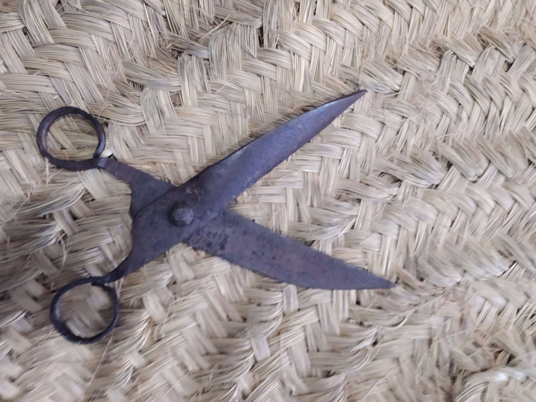 Tijera Antigua de Pelar Bestias – Alta Calidad y Valor Histórico sobre fondo de fibra natural trenzada. Ideal para decoración rústica de hogar.