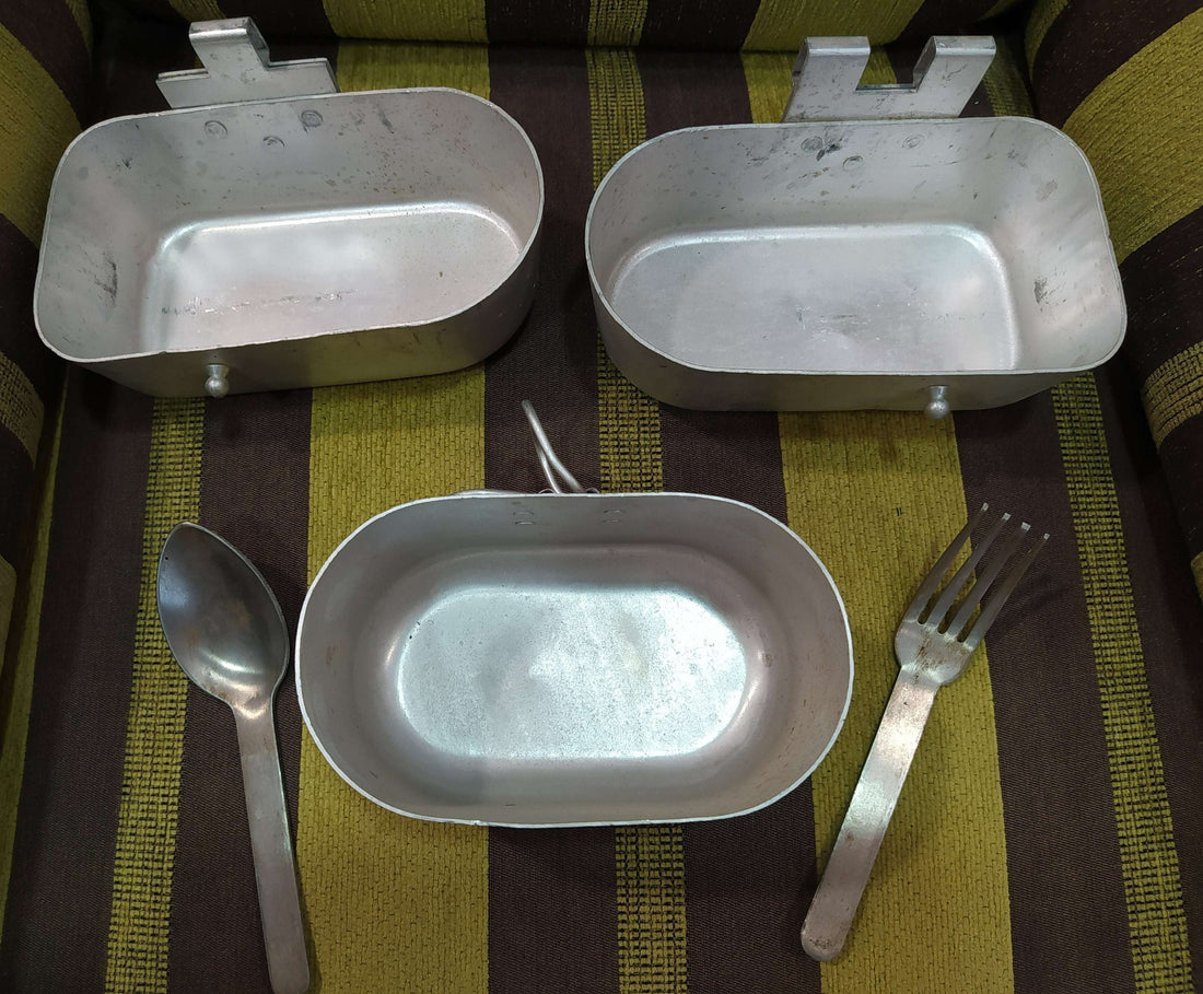 Fiambrera de aluminio antigua militar con cubiertos incluidos, ideal para decoración vintage en hogar o jardín. Incluye cuchara y tenedor metálicos.
