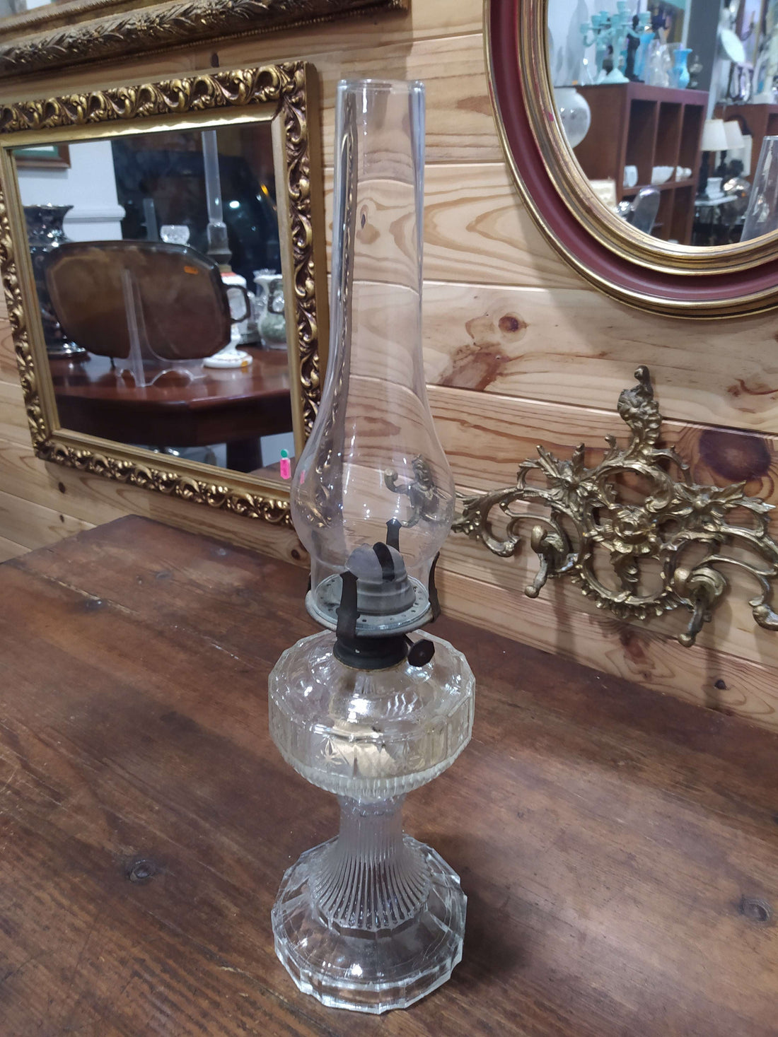 Quinque antiguo de cristal con base tallada y chimenea alta, ideal para decoración vintage en interiores elegantes. Pieza de colección con gran detalle.