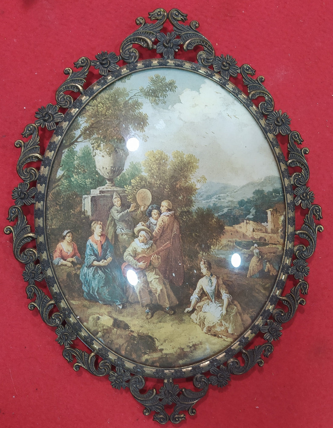 Vista frontal del cuadro italiano con marco de metal y cristal ovalado, destacando su diseño elegante y dimensiones de 39 x 30 cm.