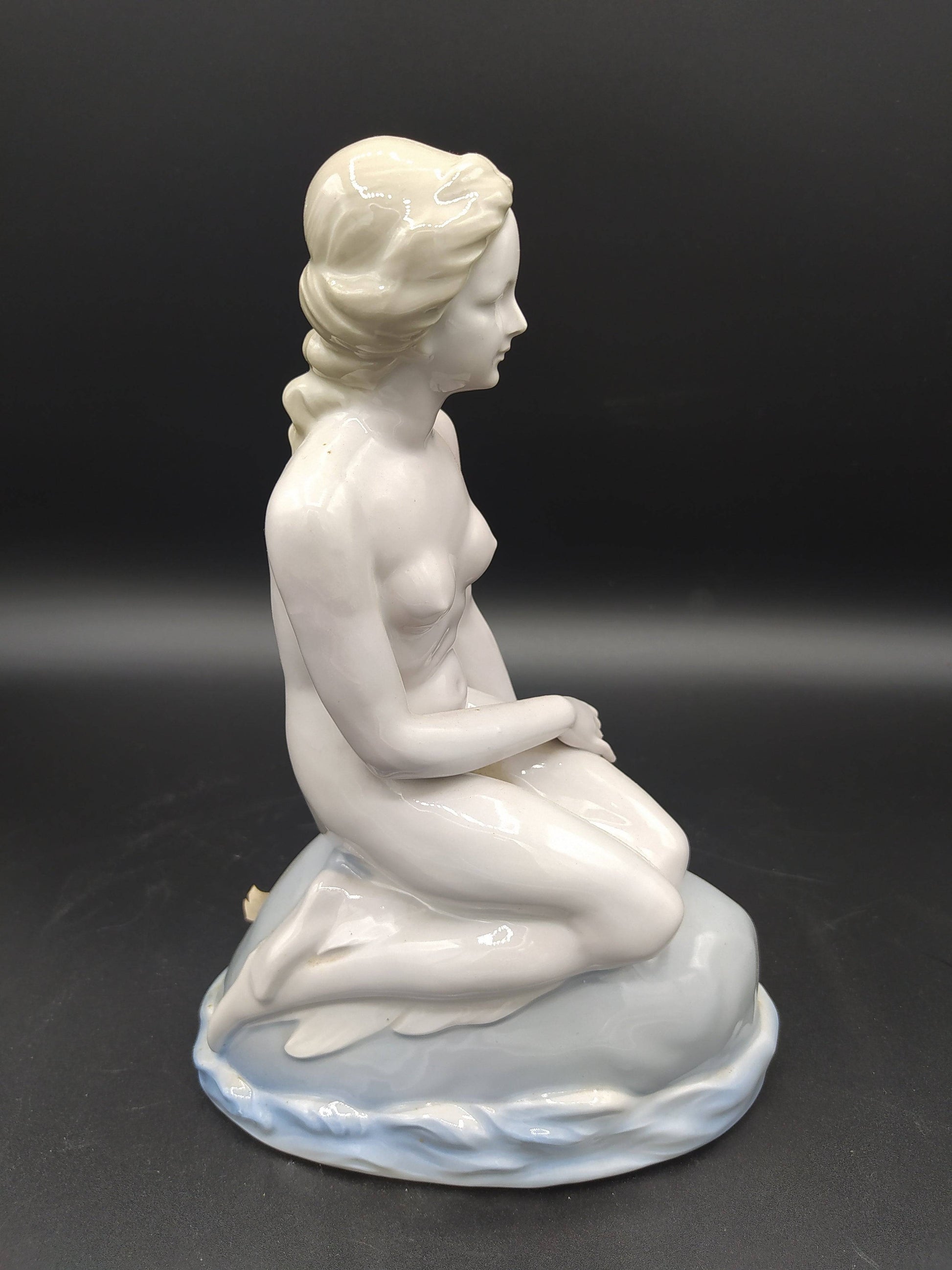 Vista lateral de la figura de La Sirenita de porcelana, mostrando detalles delicados y elegancia clásica desnuda, perfecta para coleccionistas.