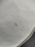 Base de la figura de porcelana con número 1801 y sello de autenticidad, indicando su valor como pieza antigua de colección decorativa.