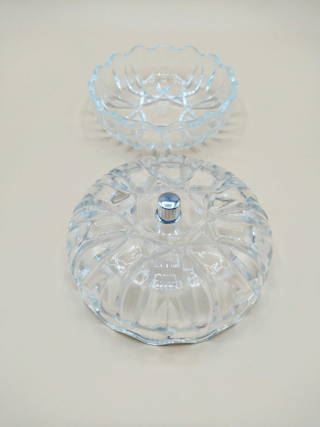 Caja-joyero de cristal con tirador de plata, diseño tallado y forma redonda, ideal para decoración elegante en el hogar. Perfecta para guardar joyas con estilo.