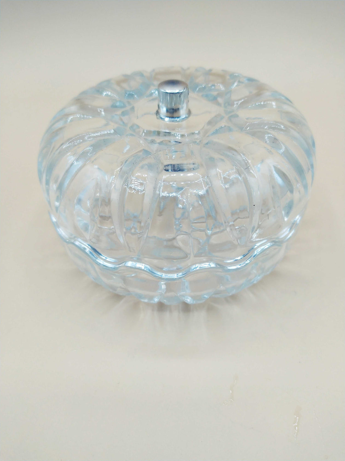 Caja-joyero de cristal con tirador de plata, diseño tallado y forma redonda, ideal para decoración elegante en el hogar. Perfecta para guardar joyas con estilo.