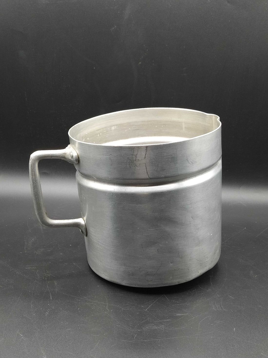 Jarro de aluminio antiguo con asa robusta y diseño clásico, ideal para decoración vintage en cocina o comedor. Calidad y autenticidad garantizadas.