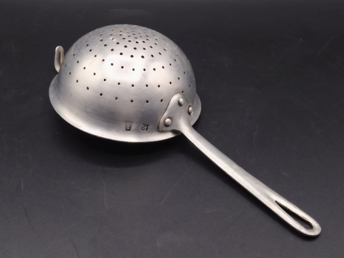  Vista lateral del colador de aluminio, mostrando su diseño clásico y su estado impecable