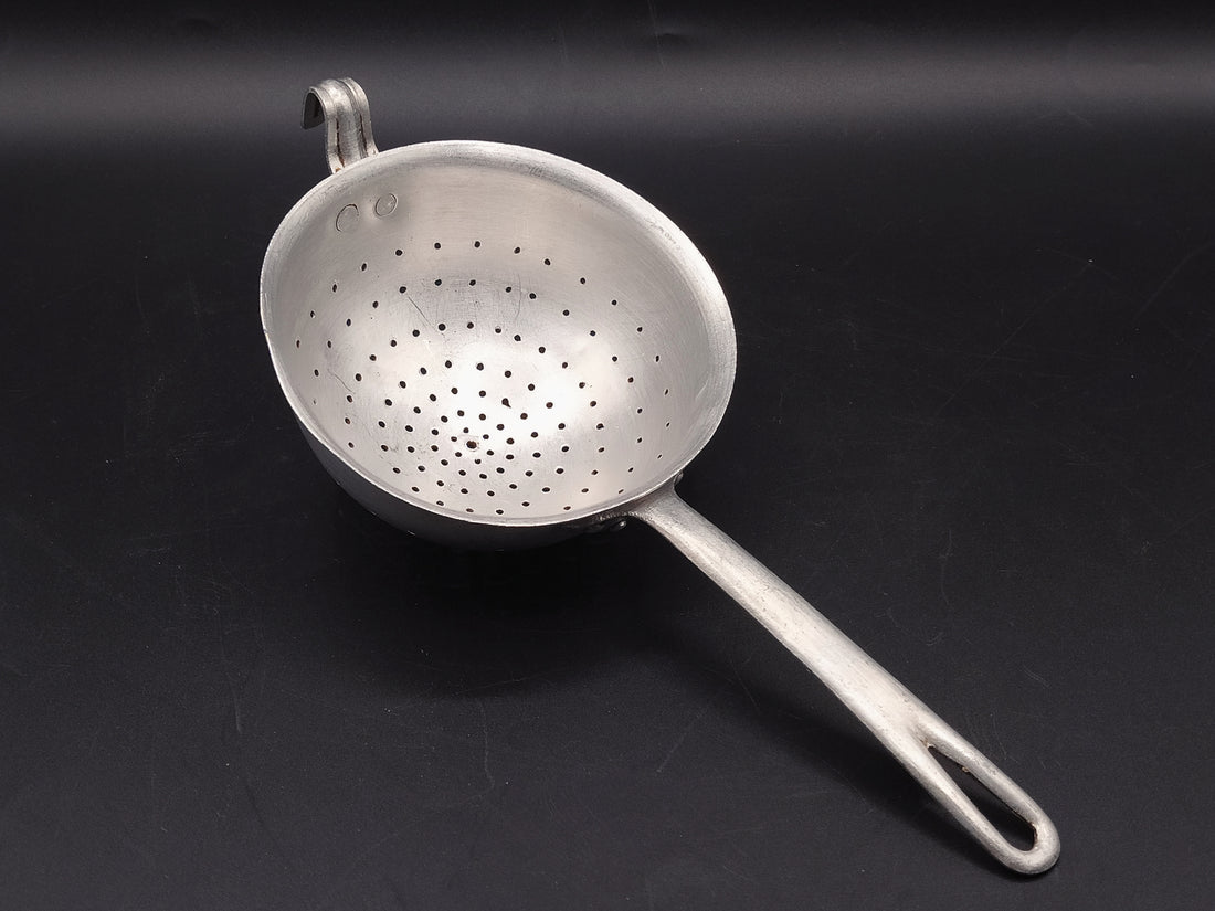  Vista lateral del colador de aluminio, mostrando su diseño clásico y su estado impecable